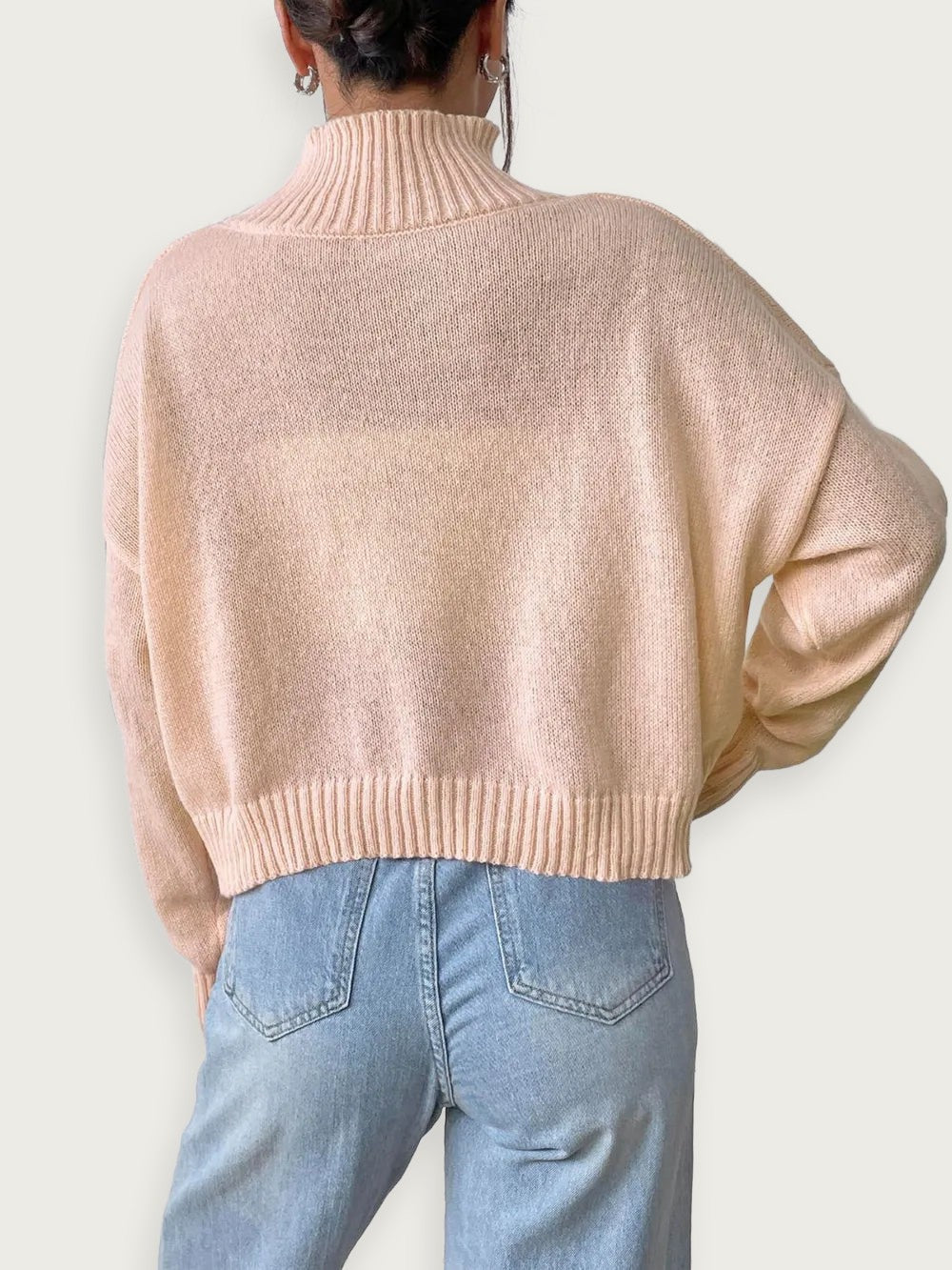 women’s high neck pullover sweater in soft pink with relaxed fit and cozy knit design from the back view.